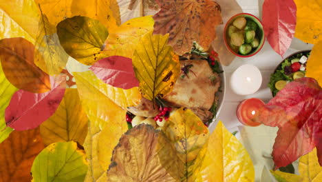 Animation-of-autumn-leaves-over-thanksgiving-dinner-background