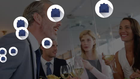 Animation-of-message-icons-floating-over-group-of-diverse-businesspeople-enjoying-drinks-at-office