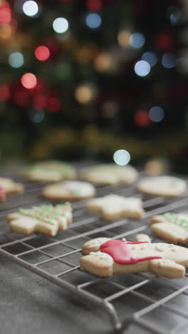 Vertical-video-of-christmas-cookies-with-sugar,-chrismtas-tree-and-copy-space-on-black-background