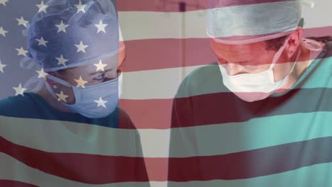 Animation-of-waving-usa-flag-over-diverse-male-and-female-surgeons-performing-operation-at-hospital
