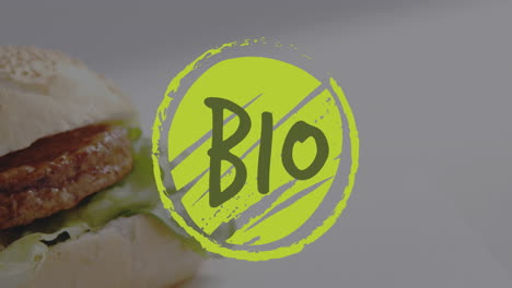 Animation-Des-Biotextes-Auf-Grünem-Logo-über-Vegetarischem-Burger-Und-Salat-Im-Brötchen
