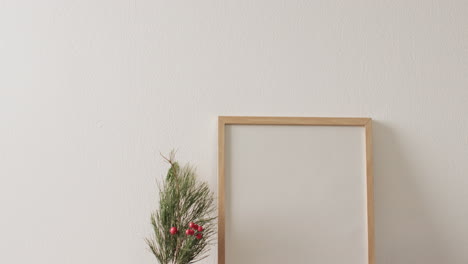 Video-of-christmas-decorations-and-wooden-frame-with-copy-space-on-white-background