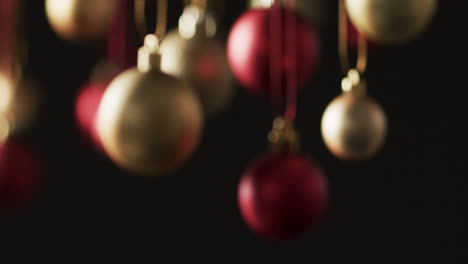 Video-of-gold-and-red-baubles-christmas-decorations-with-copy-space-on-black-background