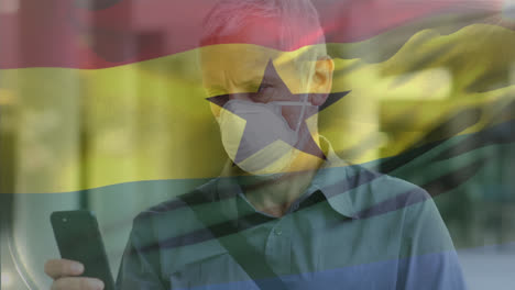 Animation-Eines-Wehenden-Ghana-Flaggen-Mannes-Vor-Einem-Kaukasischen-Mann-Mit-Gesichtsmaske,-Der-Sein-Smartphone-Auf-Der-Straße-Benutzt
