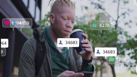 Animation-of-social-media-icons-over-biracial-albino-man-using-smartphone-drinking-coffee-on-street
