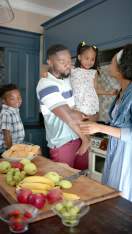 Vertical-video-of-happy-african-american-family-preparing-breakfast,-in-slow-motion