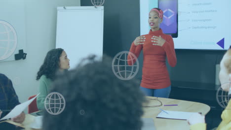 Animation-of-web-globe-floating-against-african-american-woman-giving-a-presentation-at-office