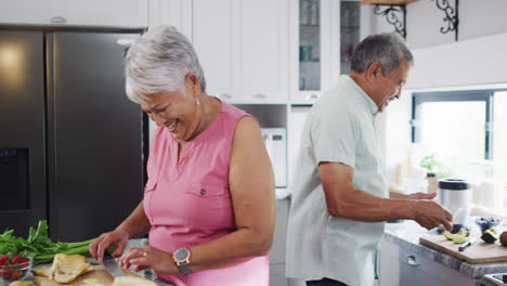 Feliz-Pareja-Birracial-Senior-Preparando-Bebidas-Saludables-En-La-Cocina