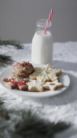 Vídeo-Vertical-De-Botella-De-Leche,-Galletas-Con-Espacio-Para-Copiar-Sobre-Fondo-De-Nieve