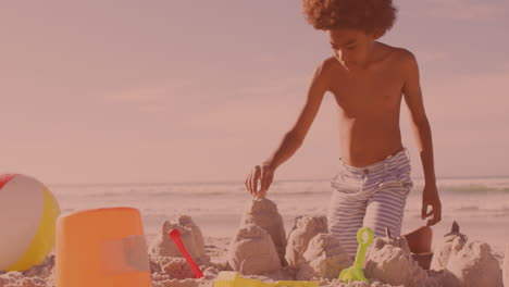 African-american-young-boy-building-sand-castles-at-the-beach