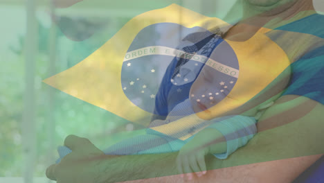 Animation-Der-Brasilianischen-Flagge-über-Einem-Kaukasischen-Mann,-Der-Ein-Baby-Hält