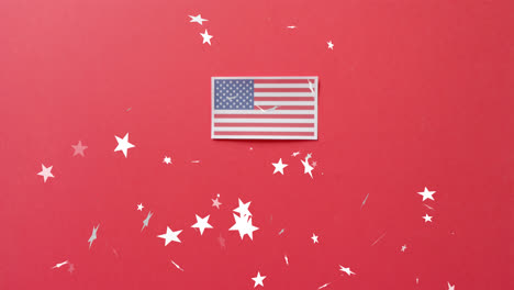 Animation-Von-Sternen,-Die-über-Die-Flagge-Der-Vereinigten-Staaten-Von-Amerika-Auf-Rotem-Hintergrund-Fallen