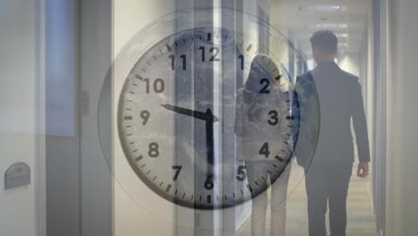 Animation-of-ticking-clock-against-rear-view-of-businessman-and-businesswoman-walking-in-office
