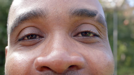 Porträt-Glücklicher-Augen-Eines-Afroamerikanischen-Mannes-Im-Sonnigen-Garten,-Zeitlupe