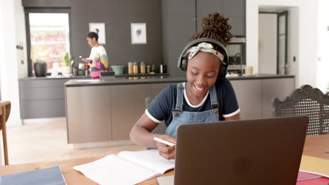 Glückliches-Afroamerikanisches-Mädchen-Im-Online-Unterricht-Mit-Kopfhörern-Und-Laptop-In-Zeitlupe