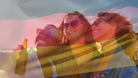 Composite-Video-Einer-Wehenden-Deutschlandflagge-über-Verschiedenen-Mädchen,-Die-Im-Freien-Neben-Einem-Auto-Ein-Selfie-Machen