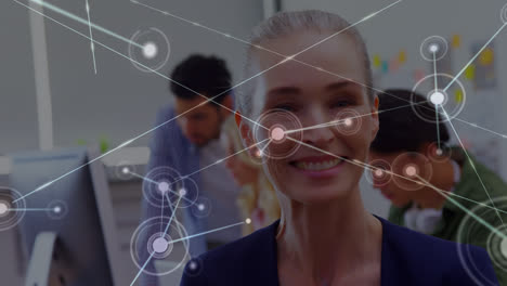 Animation-of-network-of-connections-over-happy-caucasian-woman-in-office