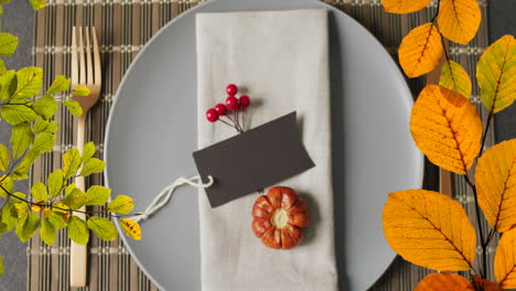 Animation-of-autumn-leaves-over-thanksgiving-dinner-place-setting-background