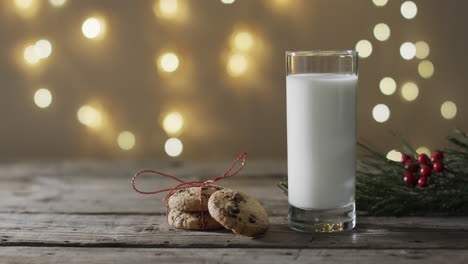 Video-of-christma-cookies,-glass-of-milk-and-copy-space-on-woodenbackground