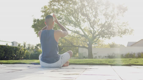 Fokussierter-Biracial-Mann,-Der-Yoga-Im-Sonnigen-Garten-Praktiziert,-Zeitlupe