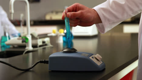 Scientist-mixing-test-tube-with-centrifuge