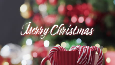 Texto-De-Feliz-Navidad-En-Blanco-Y-Bastones-De-Caramelo-Sobre-Desenfocado-Decorado-En-El-árbol-De-Navidad