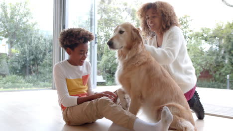 Happy-african-american-mother-and-son-sitting-on-floor,-petting-dog,-slow-motion