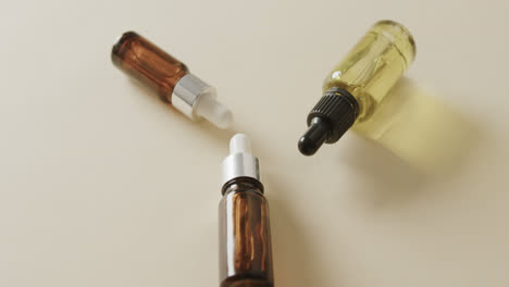 Close-up-of-three-glass-bottles-with-pumps-with-copy-space-on-beige-background-with-copy-space