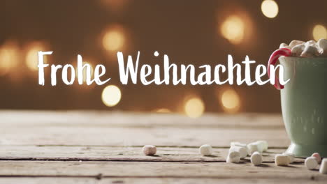 Frohe-weihnachten-text-with-candy-cane-in-christmas-hot-chocolate-with-marshmallows-and-bokeh-lights