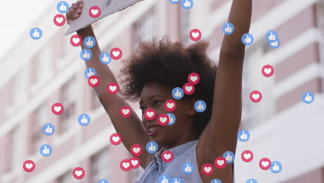 Animation-Von-Social-Media-Symbolen-über-Einem-Afroamerikaner,-Der-Während-Einer-Protestkundgebung-Ein-Plakat-Hält