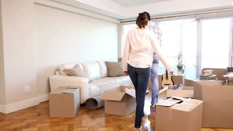 Attractive-couple-moving-boxes-into-their-living-room