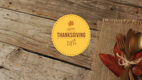 Animation-of-happy-thanksgiving-day-over-place-setting-on-wooden-background