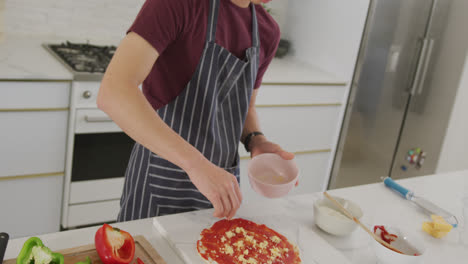 Asian-male-teenager-preparing-food-and-wearing-apron-in-kitchen