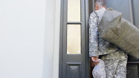 Caucasian-male-soldier-in-uniform-returning-home-walking-into-house