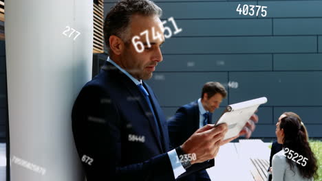 Animation-of-changing-numbers-against-biracial-businessman-using-a-tablet-and-smiling-outside-office