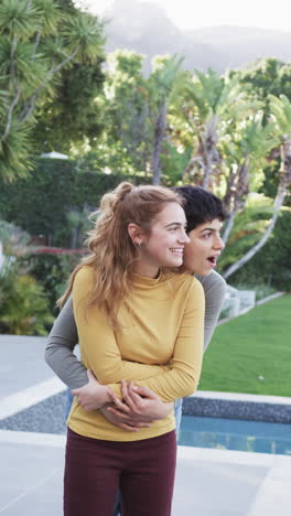 Happy-caucasian-lesbian-couple-embracing-and-smiling-in-sunny-garden