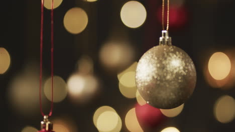 Video-of-gold-and-red-christmas-baubles-decorations-with-copy-space-on-black-background