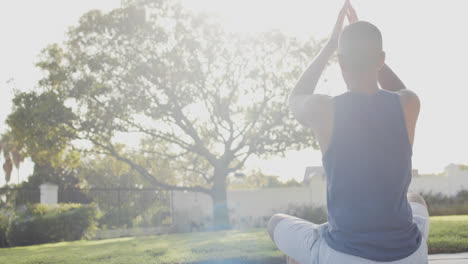Focused-biracial-man-practicing-yoga-in-sunny-garden,-slow-motion