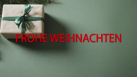 Frohe-weihnachten-text-in-red-over-christmas-gift-on-green-background