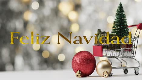 Feliz-Navidad-Text-In-Gold-über-Weihnachtsbaum-Im-Einkaufswagen-Und-Kugeln-Auf-Bokeh-Lichtern
