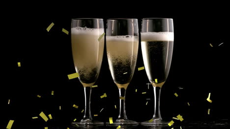 Animation-of-golden-confetti-falling-over-champagne-glasses-against-black-background