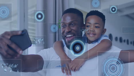 Animation-of-data-processing-against-african-american-father-and-son-taking-a-selfie-at-home