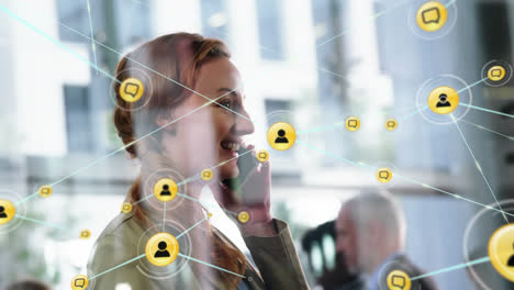 Animation-of-network-of-connections-with-icons-over-caucasian-businesswoman-talking-on-smartphone