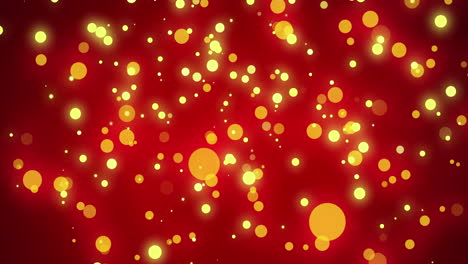 Glowing-yellow-christmas-light-particles-and-orange-bokeh-lights-moving-across-red-bokeh-background