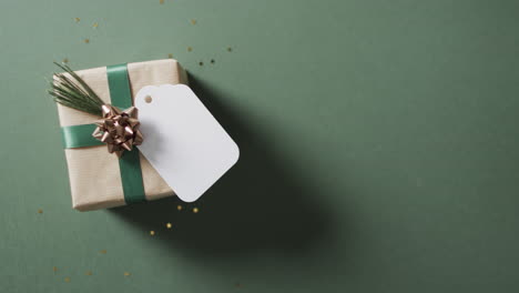 Video-of-christmas-presents-and-white-tag-with-copy-space-on-green-background