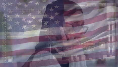 Animation-Der-Datenverarbeitung-Und-Des-Schwenkens-Der-US-Flagge-über-Einer-Gemischtrassigen-Frau-Im-Hijab,-Die-Auf-Dem-Smartphone-Spricht