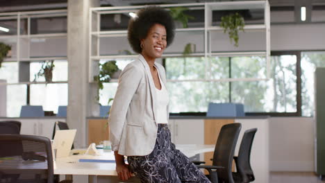 Happy-african-american-casual-businesswoman-with-afro-in-office,-slow-motion