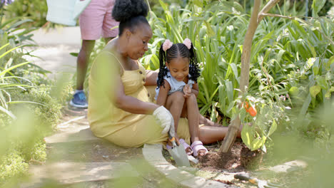 Happy-african-american-granddaughter-with-grandmother-working-in-garden,-in-slow-motion
