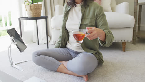 Glückliche-Asiatische-Frau-Trinkt-Tee,-Benutzt-Laptop-Und-Tablet-Im-Schlafzimmer,-In-Zeitlupe