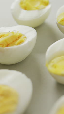 Video-of-close-up-of-halves-of-hard-boiled-eggs-on-grey-background